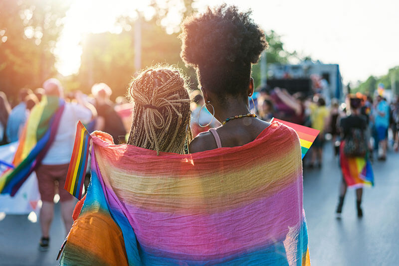 pride-women Two women wrapped in pride flag