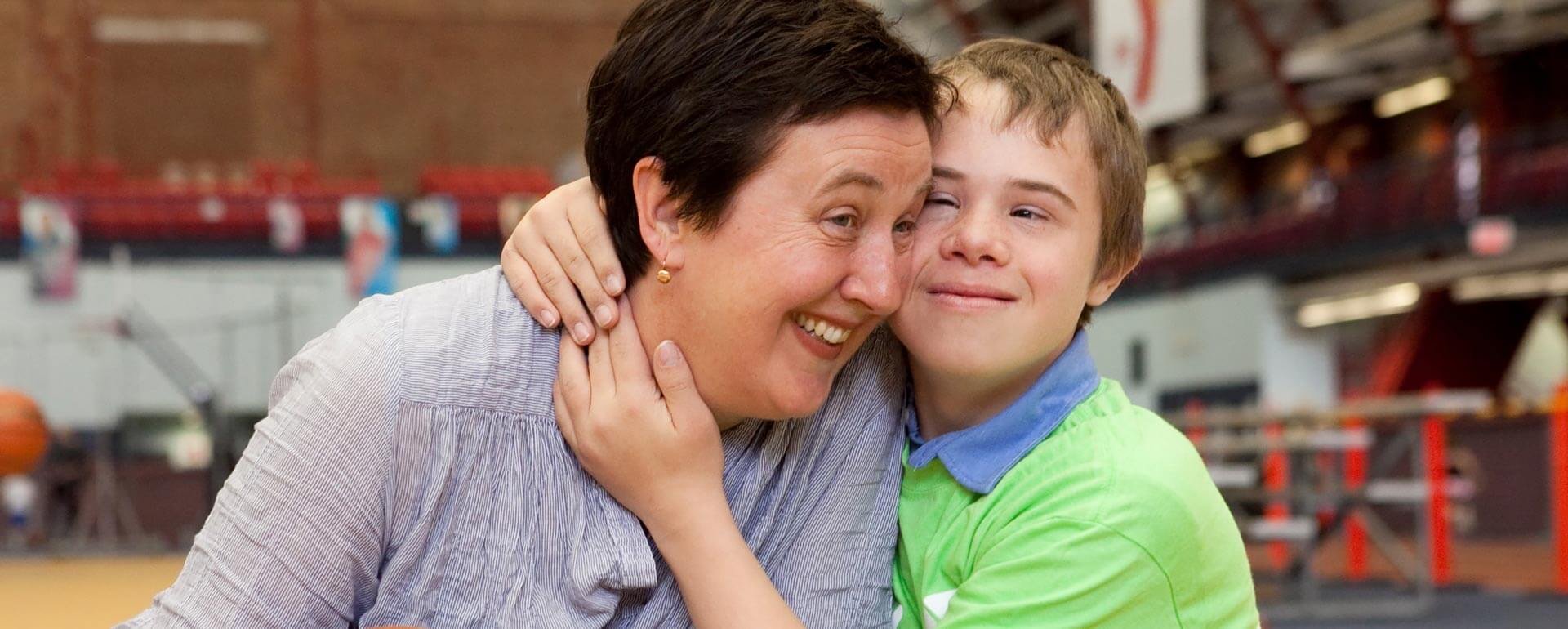 Y-hero-hugs YMCA. Child and teacher hug.
